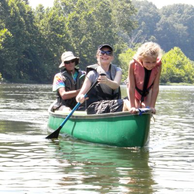 a group of people riding on the back of a boat in the water