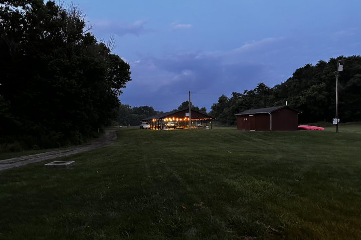 a large green field with trees in the background