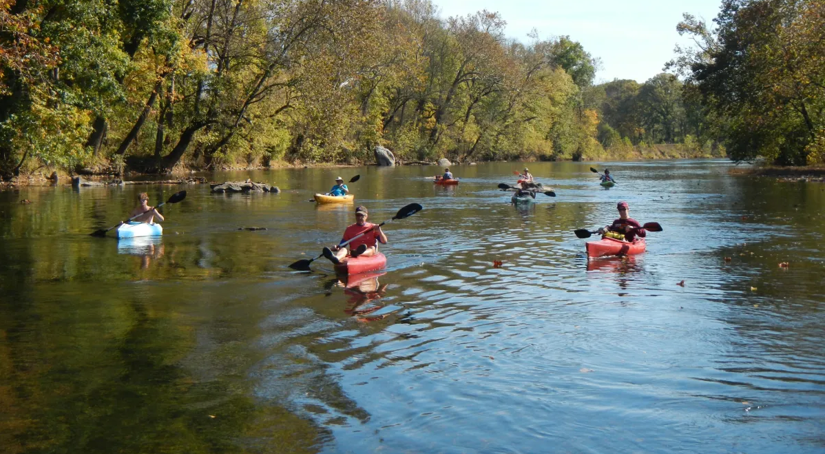 a group of people rowing a boat in the middle of a lake